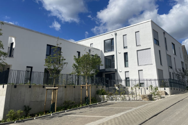 Gebäudeansicht von der Straße mit Parkplätzen